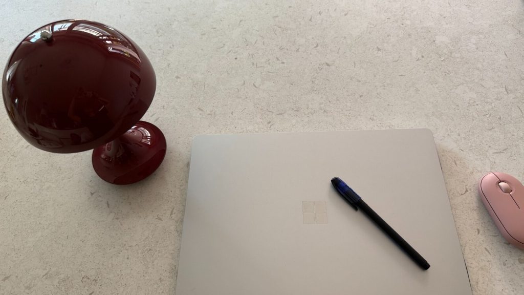 Laptop and pen on a clean office desk for monthly bookkeeping and headquarters reporting in Korea